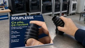 Soufflet souple en TPE imprimé en 3D pressé à la main, posé à côté de la revue Souplesse de TH Industries
